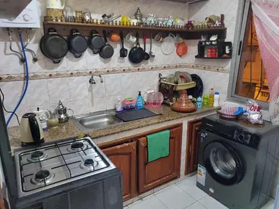 a kitchen with a stove and a sink and a washing machine at à 10 minutes du grand mall d'Afrique, WiFi Netflix 1ère étage in Oulad Hamida