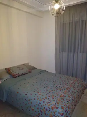 a bedroom with a bed and a chandelier at Appartement in Casablanca