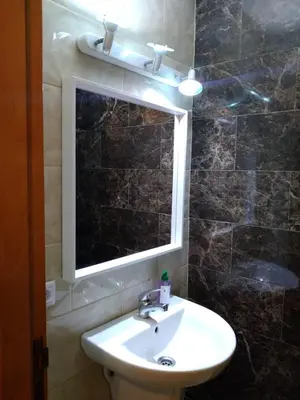 a bathroom with a sink and a mirror and a window at Appartement in Casablanca