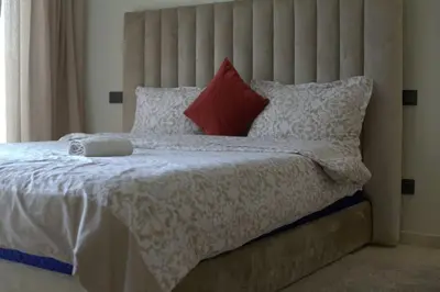 a bedroom with a bed with a large headboard and pillows at Studio cosy à Maârif, Palmiers in Maarif