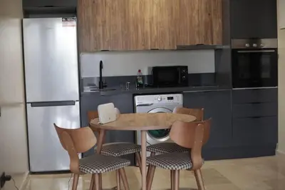 a kitchen with a table and chairs and a refrigerator at Studio cosy à Maârif, Palmiers in Maarif
