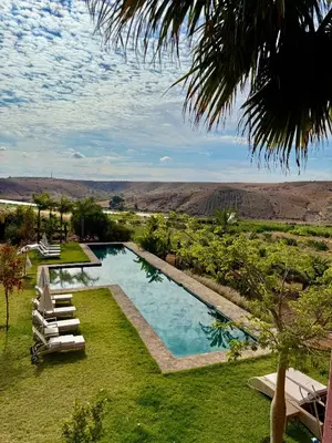 a pool with lounge chairs and a view of the desert at Kasbah Oum Rabia in Boulaouane