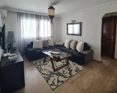a living room with a blue couch and a table at Appartement confortable et bien situé in Casablanca