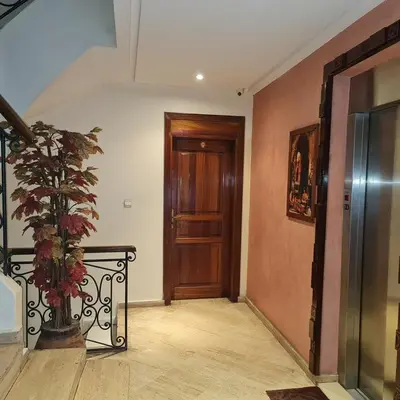 a hallway with a wooden door and a potted plant at Appartement confortable et bien situé in Casablanca