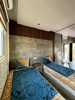 a bedroom with two beds with blue pillows at Jnane Jawhara Skhirat studio in Skhirat