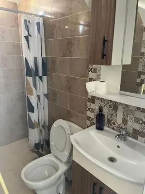 a bathroom with a white toilet and a sink at Jnane Jawhara Skhirat studio in Skhirat