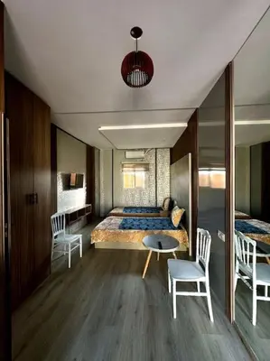 a bedroom with a bed and a table and chairs at Jnane Jawhara Skhirat studio in Skhirat