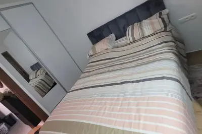 a large bed in a bedroom with a striped bedspread at Appart à Malaga Beach Mansouria in Mansouria