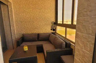 a couch and a table in a room with a window at Appart à Malaga Beach Mansouria in Mansouria