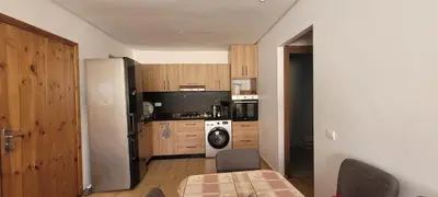 a kitchen with a refrigerator and a table with chairs at Appart à Malaga Beach Mansouria in Mansouria