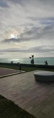 a bench in a park with the ocean in the background at le carrousel Rabat Océan in Kouas