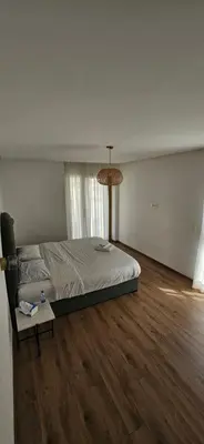 a bedroom with a bed and a wooden floor at le carrousel Rabat Océan in Kouas
