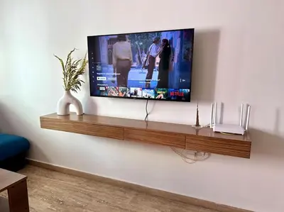 a flat screen tv on a wall with a shelf at Cosy and practical apartment in Maarif