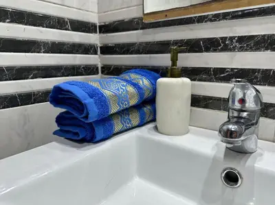 a bathroom sink with blue towels and a faucet at Cosy and practical apartment in Maarif