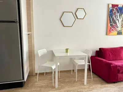 a white table with chairs and a red couch at Cosy and practical apartment in Maarif