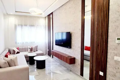 a living room with a couch and a tv at Chic & Charme Studio Près de l'aéroport in Nouaceur