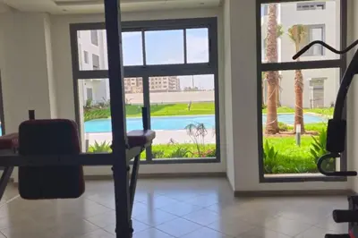 a room with a view of a pool through a window at Chic & Charme Studio Près de l'aéroport in Nouaceur