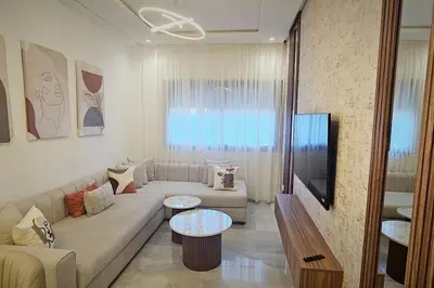 a living room with a couch and a table at Chic & Charme Studio Près de l'aéroport in Nouaceur