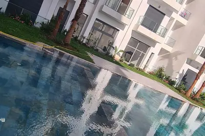 a swimming pool in front of a building at Chic & Charme Studio Près de l'aéroport in Nouaceur