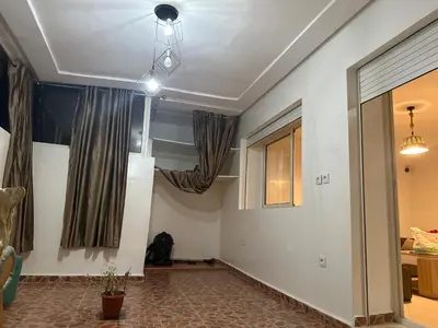 a living room with a pendant light and curtains at Charmant appt 2 ch terrasse in Rabat