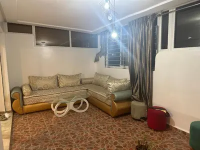 a living room with a couch and a table at Charmant appt 2 ch terrasse in Rabat