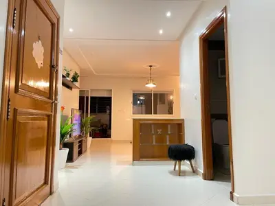 a hallway with a wooden door and a black stool at Charmant appt 2 ch terrasse in Rabat