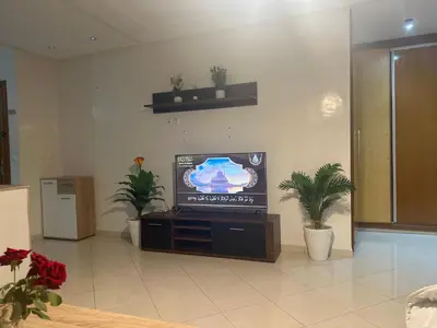 a living room with a flat screen tv and plants at Charmant appt 2 ch terrasse in Rabat