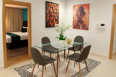 a dining room with a glass table and chairs at studio by rent inn in Rabat