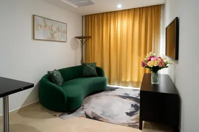 a living room with a green couch and a vase of flowers at studio by rent inn in Rabat