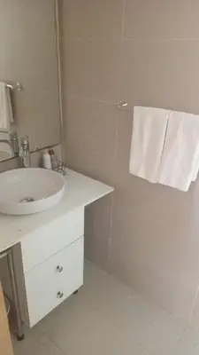 a bathroom with a sink and a shower with a mirror at studio by rent inn in Rabat