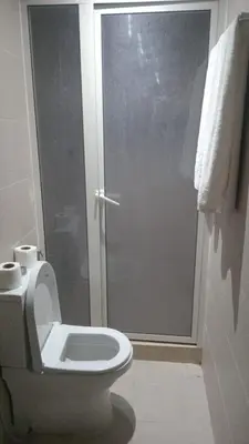 a bathroom with a toilet with a glass shower door at studio by rent inn in Rabat