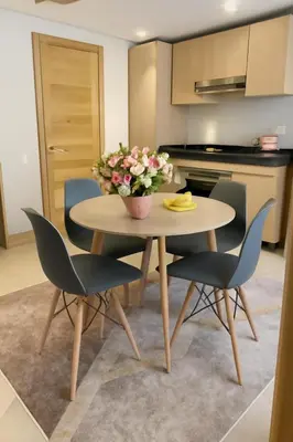 a kitchen with a table and chairs with a vase of flowers at studio by rent inn in Rabat
