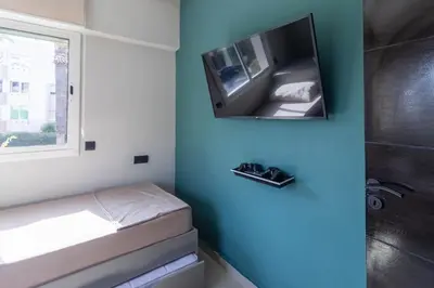a bathroom with a tub and a television on the wall at Duplex Chic & Design Unique au bord de la mer ! in Mohammedia