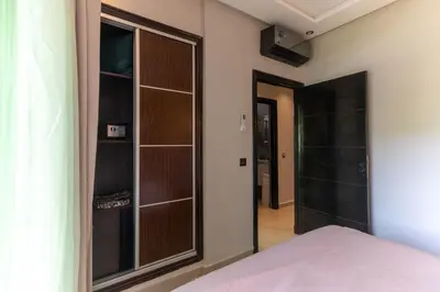 a bedroom with a closet with a glass door at Duplex Chic & Design Unique au bord de la mer ! in Mohammedia