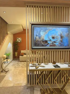 a living room with a painting on the wall at Duplex Chic & Design Unique au bord de la mer ! in Mohammedia