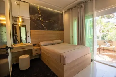 a bedroom with a bed with a vanity and a mirror at Duplex Chic & Design Unique au bord de la mer ! in Mohammedia
