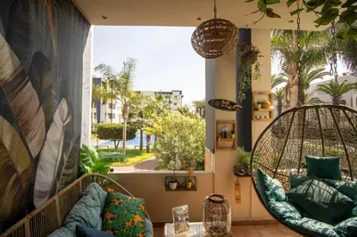 a room with a hanging chair and a large window at Duplex Chic & Design Unique au bord de la mer ! in Mohammedia