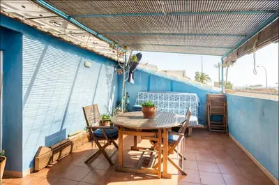 a balcony with a table and chairs on a blue wall at Maison du bonheur in Casablanca