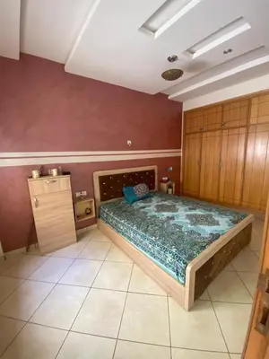 a bedroom with a large bed in a room at duplex in Oulad Lahsene