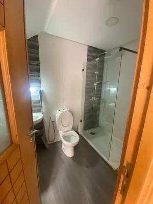 a bathroom with a toilet and a glass shower at duplex in Oulad Lahsene