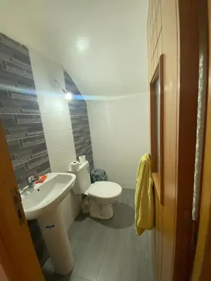 a small bathroom with a toilet and a sink at duplex in Oulad Lahsene