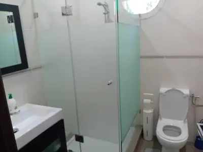 a bathroom with a toilet and a shower and a sink at Superbe villa à Bouznika in Bouznika