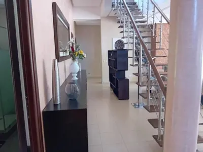 a hallway with stairs and a vase with flowers in it at Superbe villa à Bouznika in Bouznika
