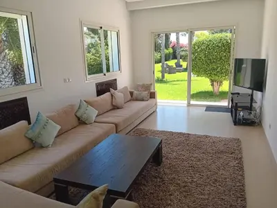 a living room with a couch and a coffee table at Superbe villa à Bouznika in Bouznika