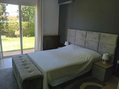 a bedroom with a bed and a large window at Superbe villa à Bouznika in Bouznika