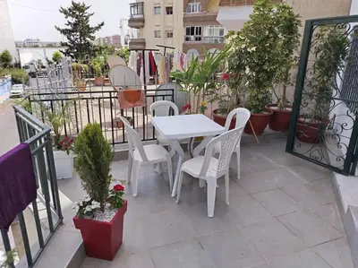 a white table and chairs on a balcony with plants at Joli Apparemment et calme in Casablanca