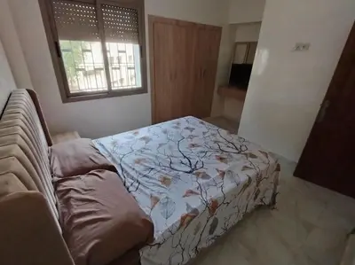 a bedroom with a bed and a couch and a window at Joli Apparemment et calme in Casablanca