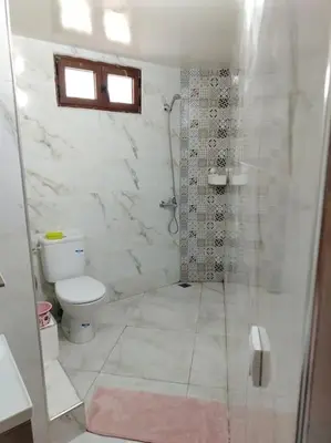 a white bathroom with a shower and a toilet at Joli Apparemment et calme in Casablanca