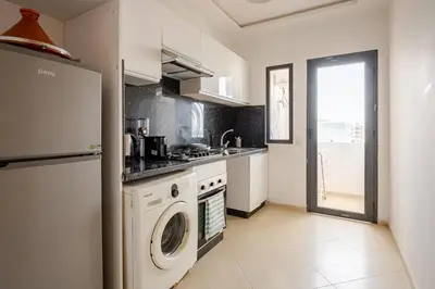 a kitchen with a washing machine and a sink at Residence GYA Beach - Luxe Moderne et Confort à Harhoura accès plage in Temara
