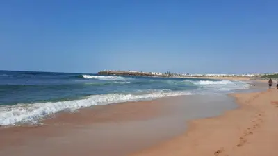 a beach with footprints in the sand and the ocean at Residence GYA Beach - Luxe Moderne et Confort à Harhoura accès plage in Temara